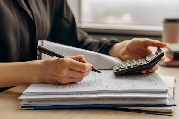 person reviewing income tax material with a calculator in hand