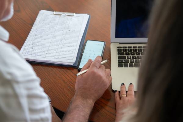 two people reviewing a clipboard with documents